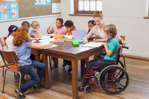 Teacher Helping Students in Elementary Classroom